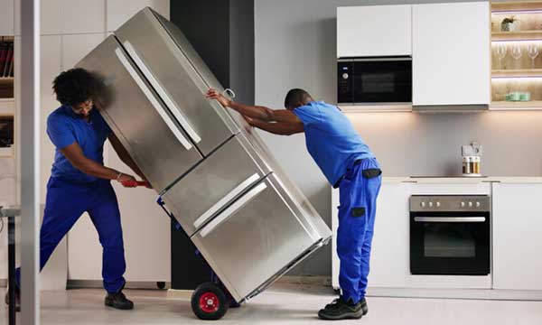 Technician diagnosing and repairing a refrigerator at a Nairobi residence